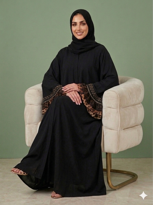 An elegant black abaya featuring flared bell sleeves with leopard-print trim